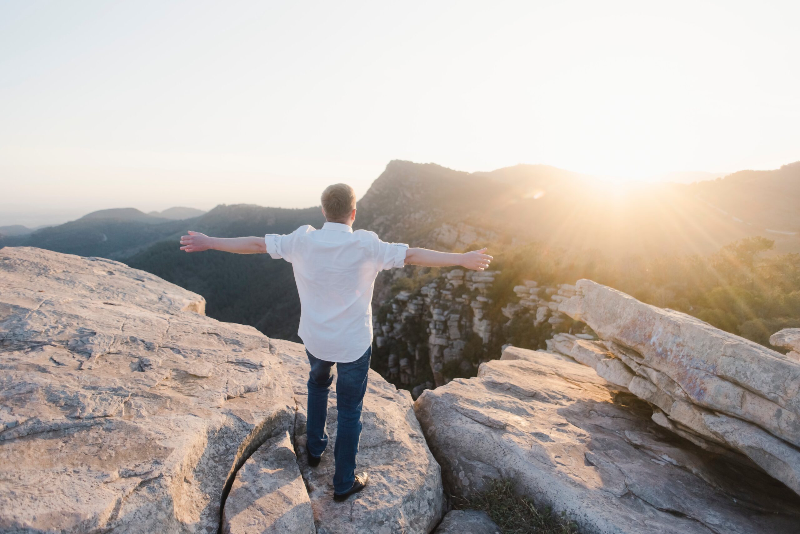Man on top of mountain with outstretched arms