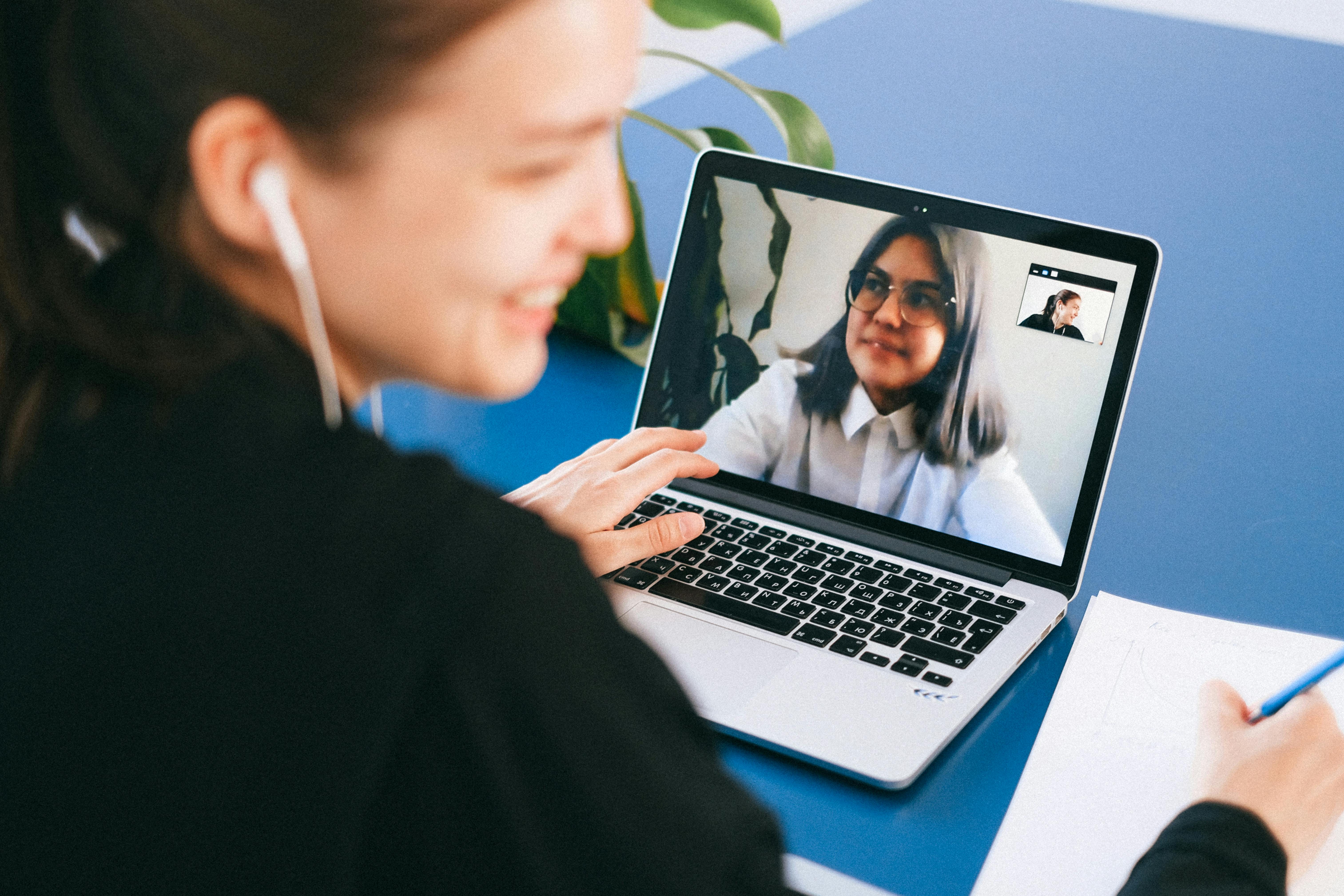 A client attending a virtual therapy session and taking notes.
