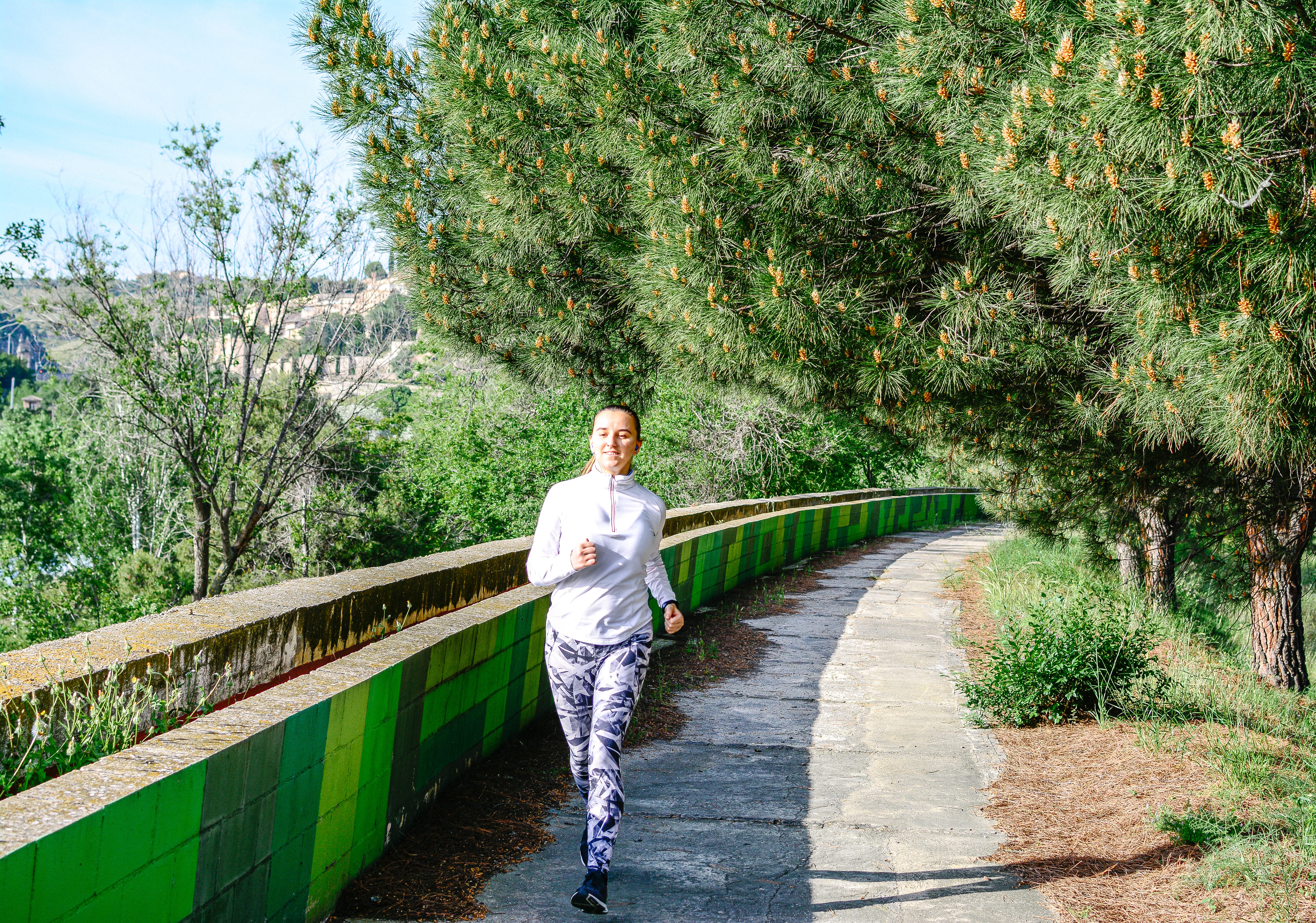A woman running outside, which is a natural way to improve mental health.