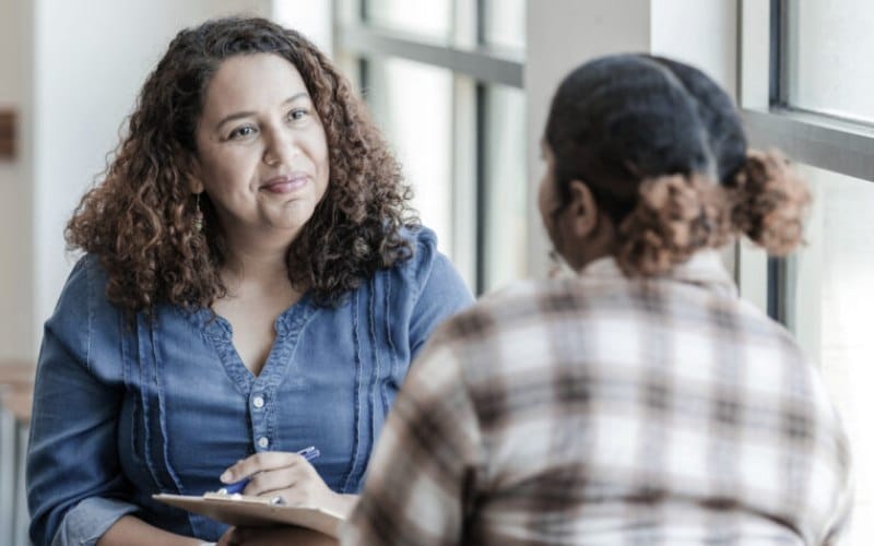 An older woman in a Half-Day Outpatient Treatment Program session at a Meta Addiction Treatment facility.