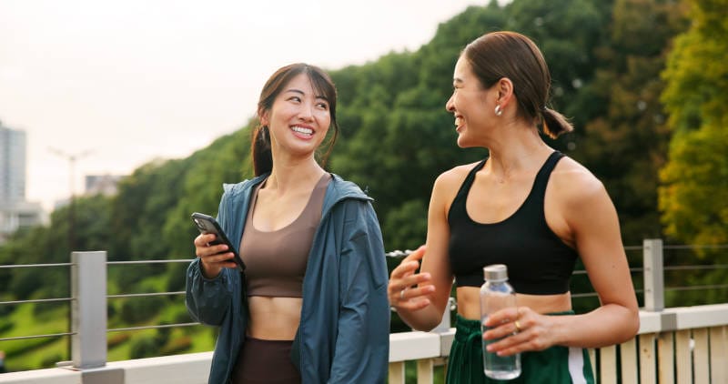Two women on a healthy walk, a sign of progress during mental health treatment.
