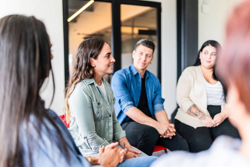 A group therapy session between adults, an important part of recovery.